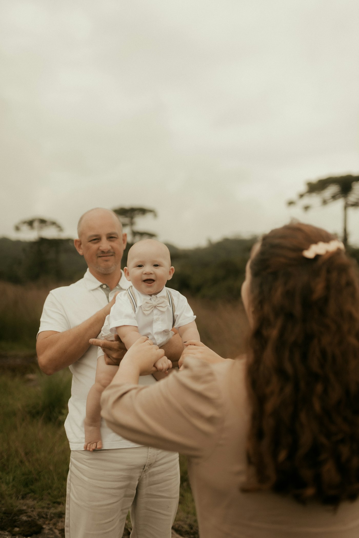 En far holder sit smilende barn. En familie sammen derhjemme.